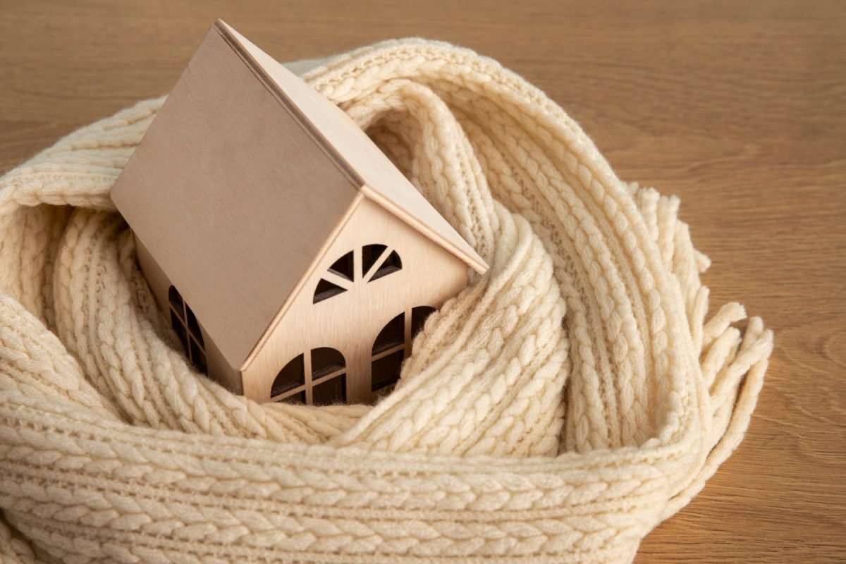 petite maison en bois entourée d'une echarpe bien chaude